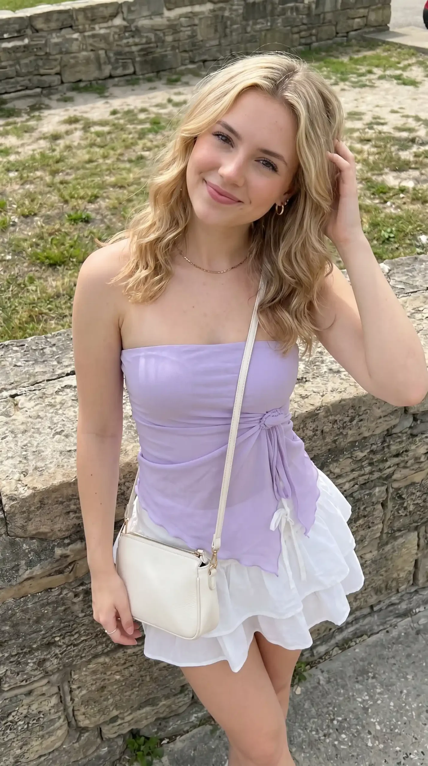 Woman wearing lavender tie-waist tube top with white tiered ruffle skirt outdoors