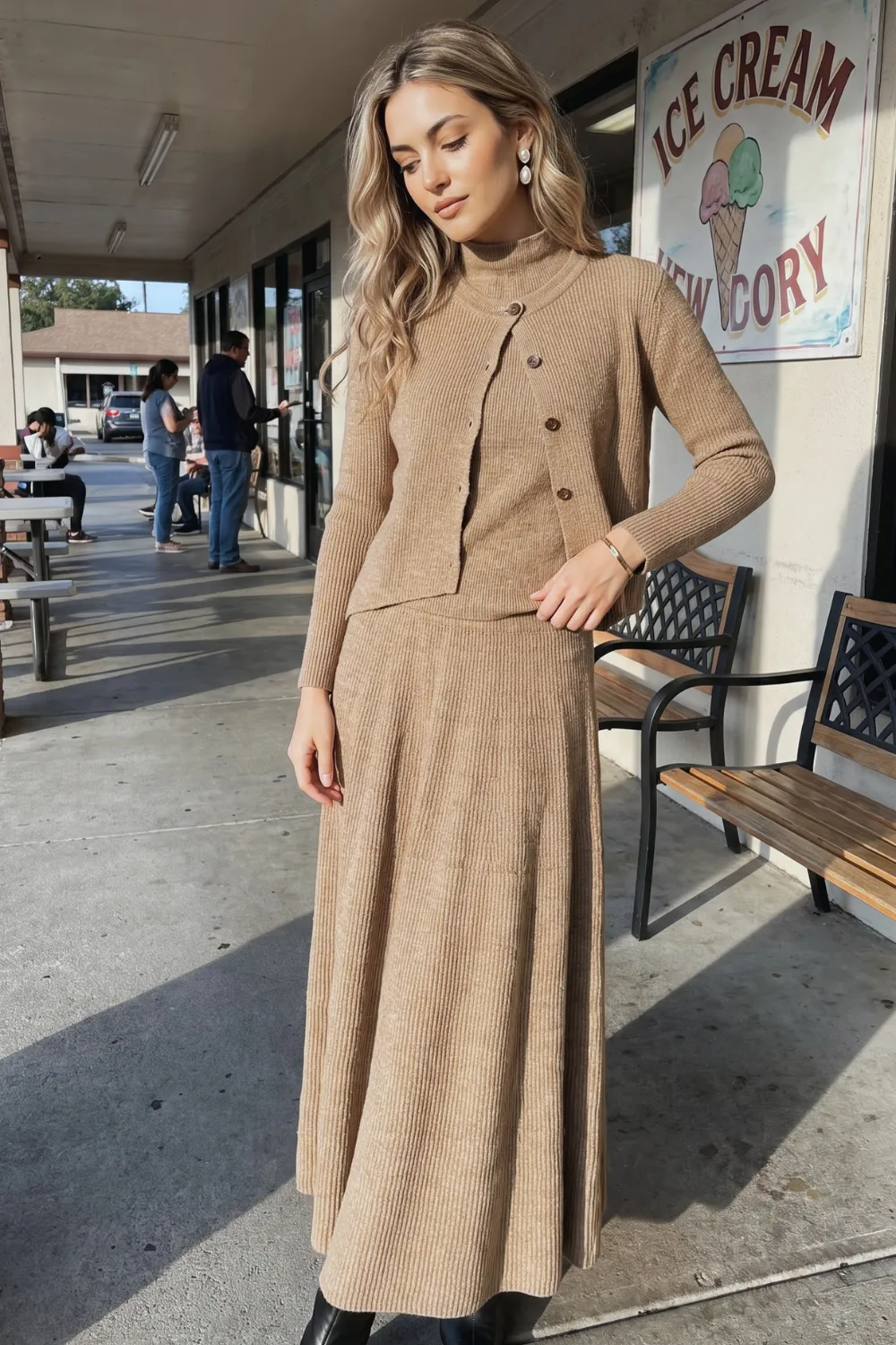 Woman in camel ribbed knit cardigan and midi skirt co-ord set with black boots
