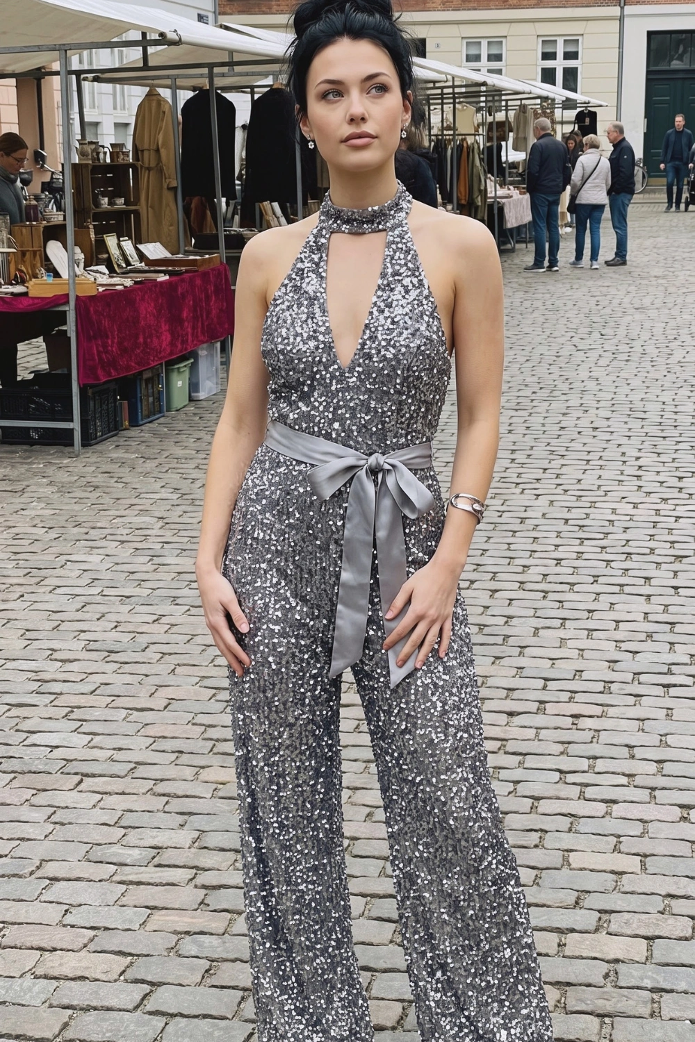 Woman in silver grey sequin halter neck deep v bow belt wide leg jumpsuit