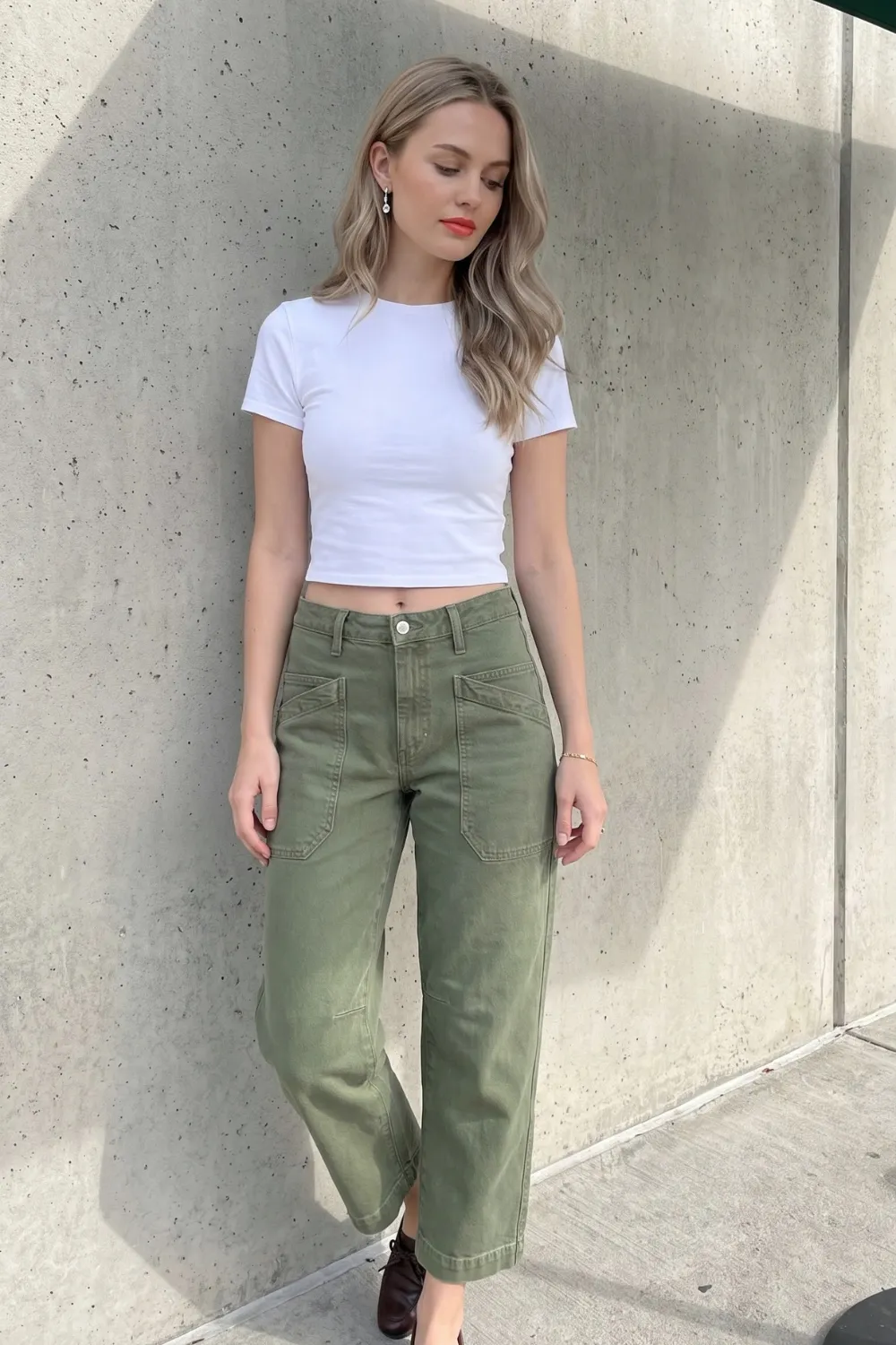 Woman in white crop baby tee with olive green patch pocket barrel jeans and dark brown boots